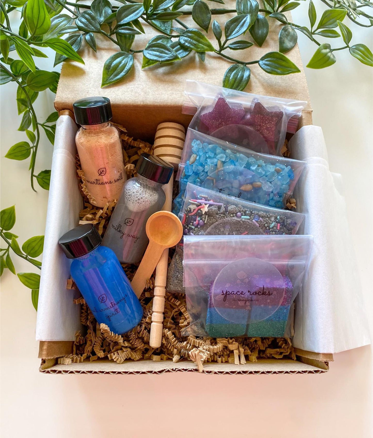 The Magic Folks Sensory Potion Kit unboxed — labeled bottles alongside sealed bags of Space Rocks and glittery star and crystal sensory pieces, packaged in kraft box with wooden scoop and dipper